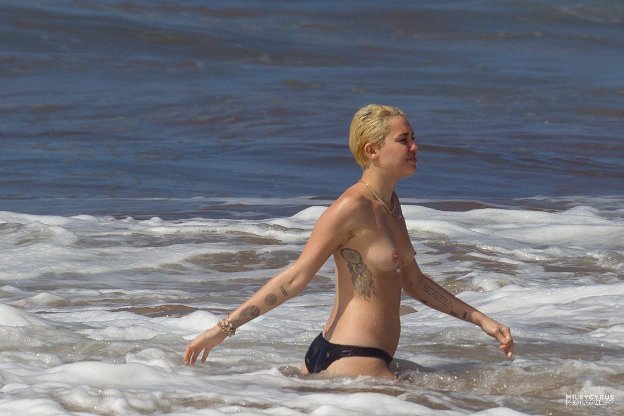 Майли Сайрус показала голую грудь на пляже.